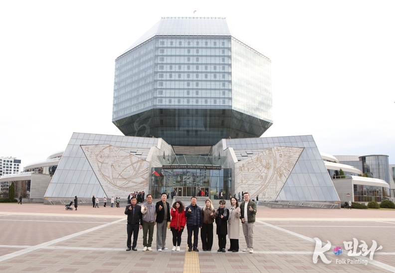 벨라루스 민스크의 상징적 건축물인 국립도서관(National Library of Belarus) 앞에서 한국 대표단이 기념촬영을 하고 있다. 팔각형 다이아몬드 형태의 독창적인 외관은 ‘지식의 보석’을 상징하며, 밤이 되면 건물 전체에 LED 조명이 켜져 붉고 푸른 빛으로 환하게 빛나 도시의 랜드마크로 변신한다. 지성의 상징이자 예술적 건축미를 겸비한 이곳은 민스크 시민들이 가장 자랑스러워하는 문화공간이다.( 사진-최동호 국장)