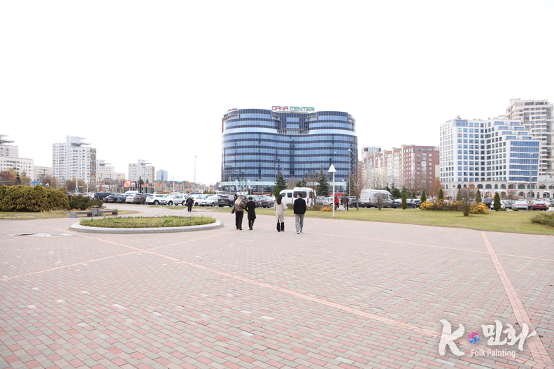  벨라루스 민스크 국립도서관 앞 광장의 전경. 도서관을 등지고 바라본 도심 풍경에는 현대식 빌딩과 상업시설이 조화를 이루며, 중앙에 자리한 둥근 광장이 시민들의 산책로와 휴식 공간으로 활용되고 있다. 도심 속에서도 여유와 질서가 느껴지는 민스크의 일상 풍경이 고요하게 펼쳐진다.(사진-최동호 국장)